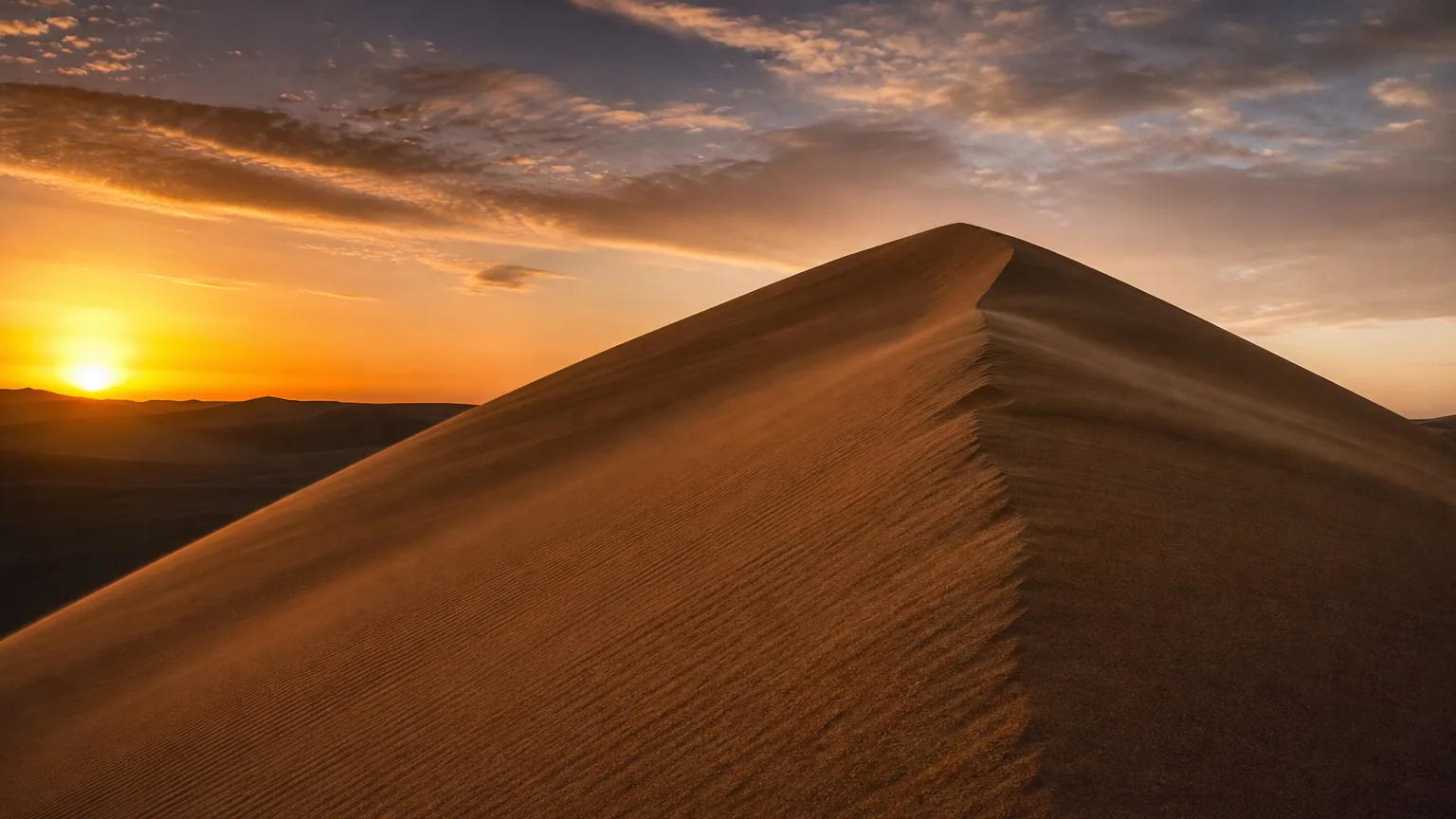 Grande dune de sable désertique au coucher du soleil, crête nette, ombres marquées sur le versant.