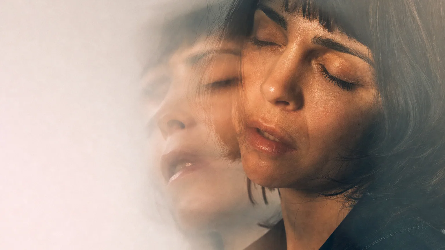 Visage d'une personne aux yeux fermés en effet de double exposition évoquant un souvenir flou